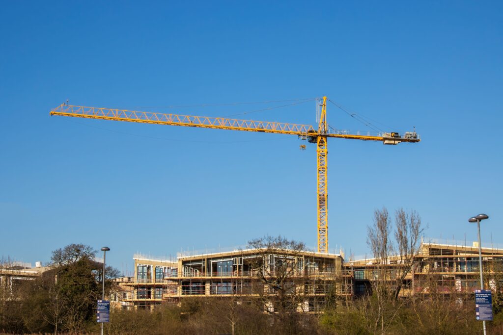 Apartment building site with crane with a blue sky. High Quality Image
