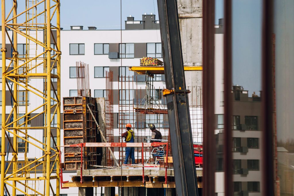 Workers engineers working at construction site and cranes on background of new building skyscrapers. Industrial landscape with building steel and concrete. worker engineer looking at development